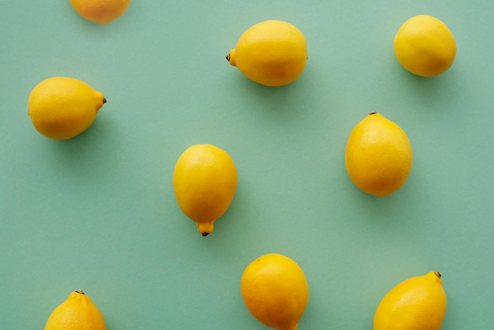 Hand holding a lemon against a bright yellow background, representing fresh approach to pleasure without pressure