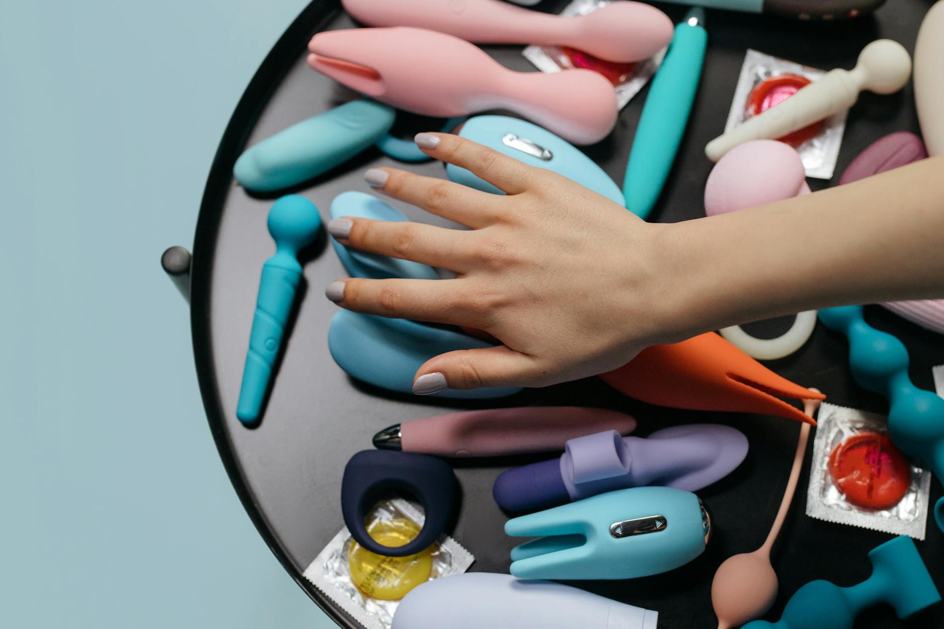 Close-up of hands holding a vibrator against a knitted sweater, intimate and private