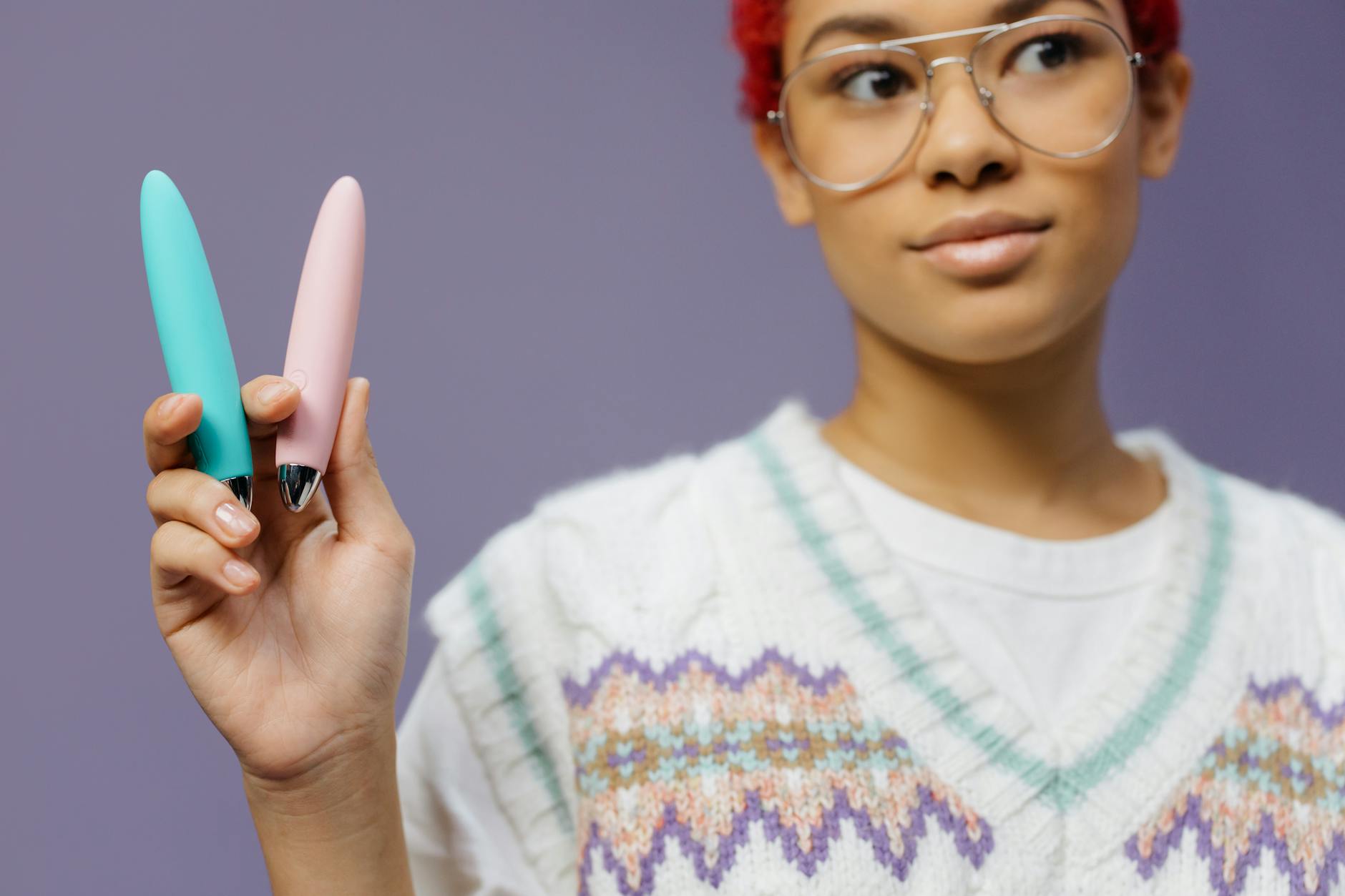 Two vibrators held together against a purple background, symbolizing shared pleasure and partnership.