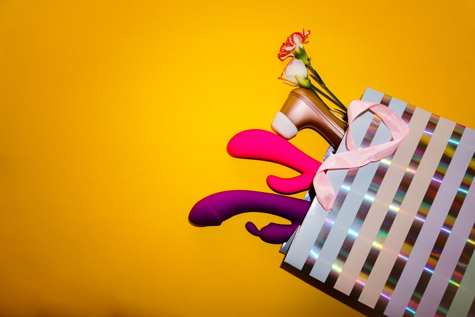 Colorful lemon vibrators and clitoral toys arranged in a bright, celebratory composition against yellow background