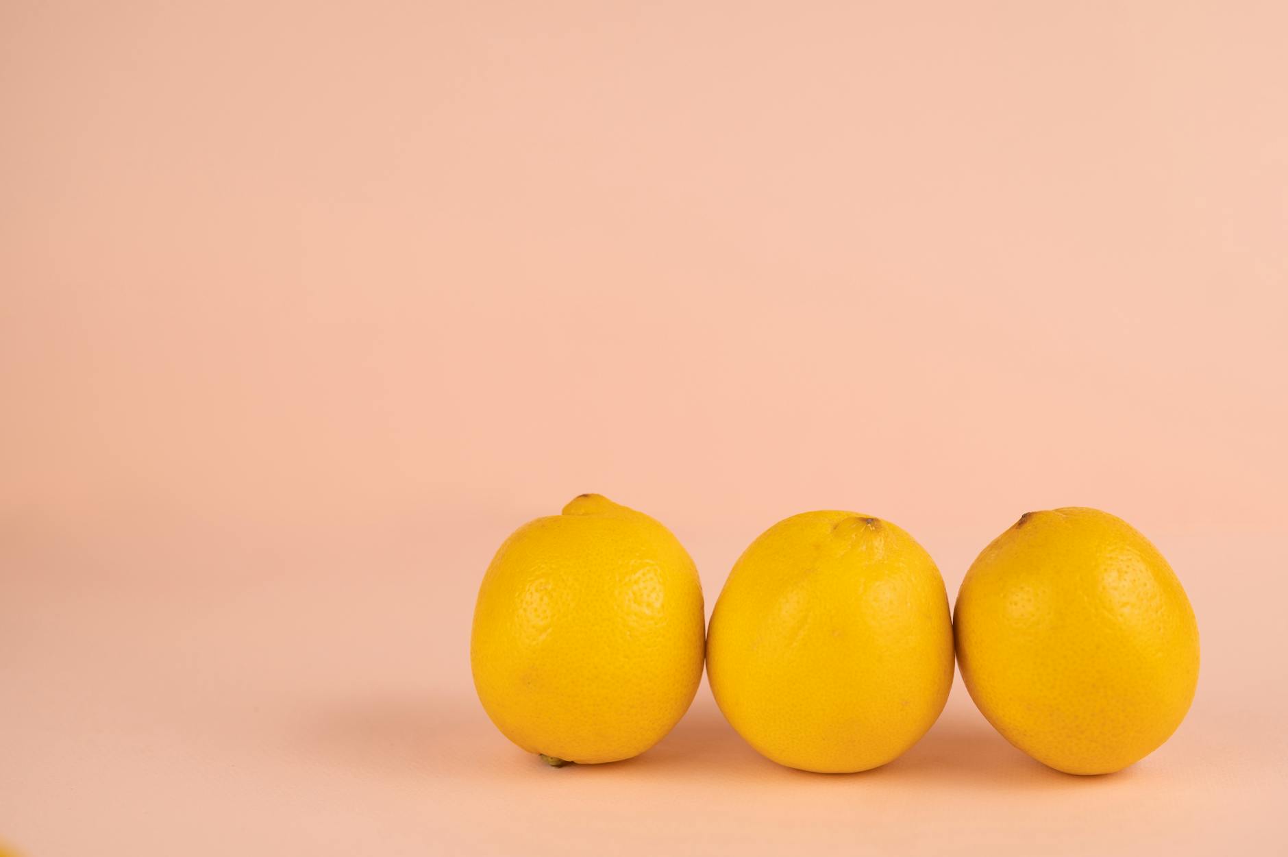 Hand holding a lemon vibrator against a minimalist purple background, representing intentional self-reconnection