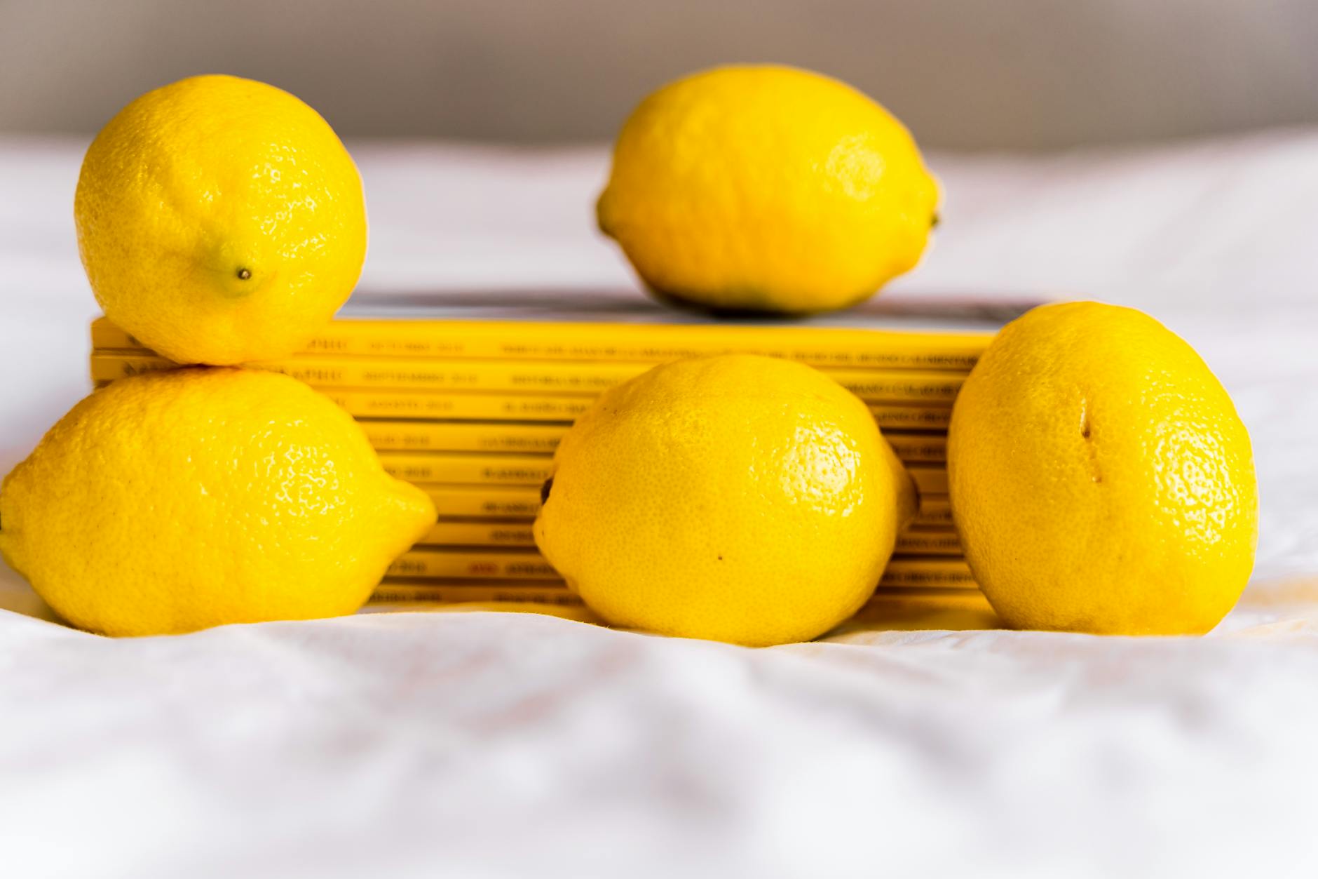 Hand holding a fresh lemon against a bright yellow background, symbolizing renewal and gradual recovery